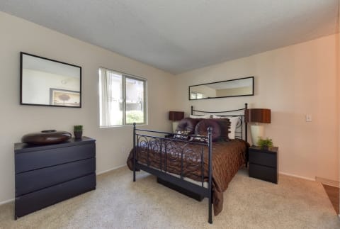 Furnished bedroom with bed, dresser and nightstand.